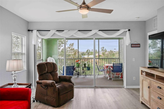 sitting room with a healthy amount of sunlight, ceiling fan, and light hardwood / wood-style floors