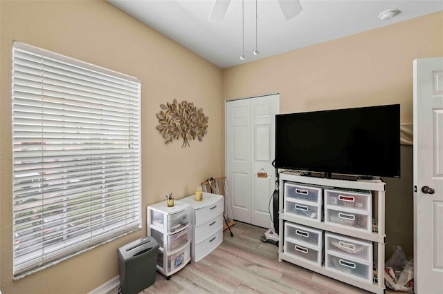 bedroom with light wood-type flooring, ceiling fan, and a closet