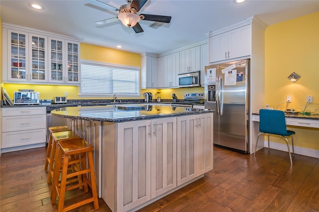 kitchen featuring white cabinetry, appliances with stainless steel finishes, a center island, and dark hardwood / wood-style flooring