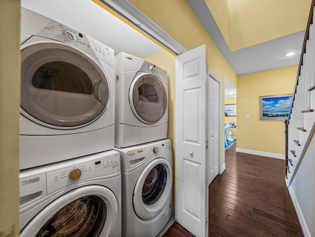 clothes washing area featuring stacked washer and clothes dryer and dark hardwood / wood-style flooring