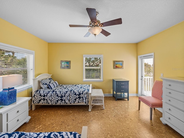 bedroom featuring multiple windows, access to exterior, and ceiling fan