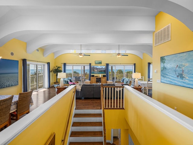 staircase with hardwood / wood-style flooring and vaulted ceiling with beams