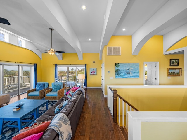 living room with dark hardwood / wood-style flooring, ceiling fan, and beamed ceiling