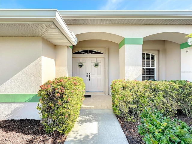 entrance to property featuring stucco siding