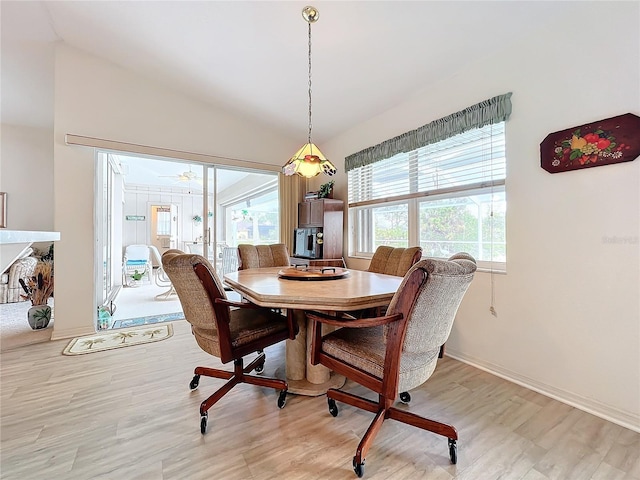 dining space with light wood-type flooring and lofted ceiling