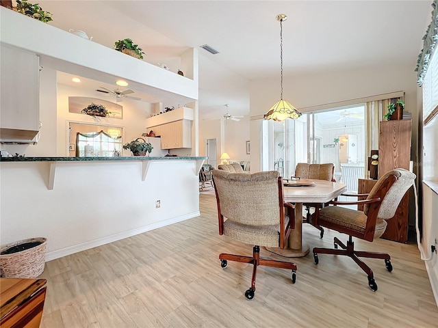 dining room with ceiling fan, high vaulted ceiling, and light wood-type flooring