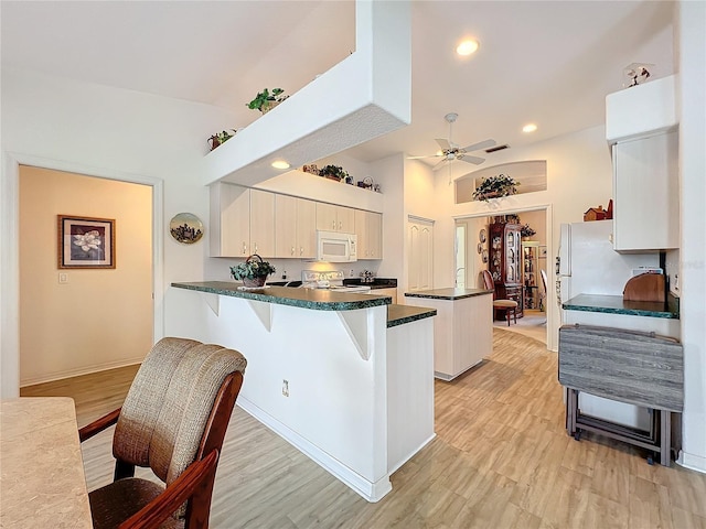 kitchen featuring ceiling fan, electric stove, kitchen peninsula, and light hardwood / wood-style floors