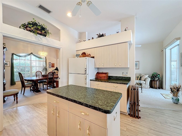 kitchen featuring visible vents, a kitchen island, light wood-style flooring, and freestanding refrigerator