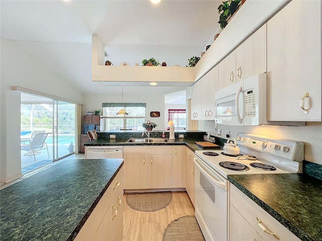 kitchen with white appliances, sink, decorative light fixtures, light hardwood / wood-style flooring, and vaulted ceiling