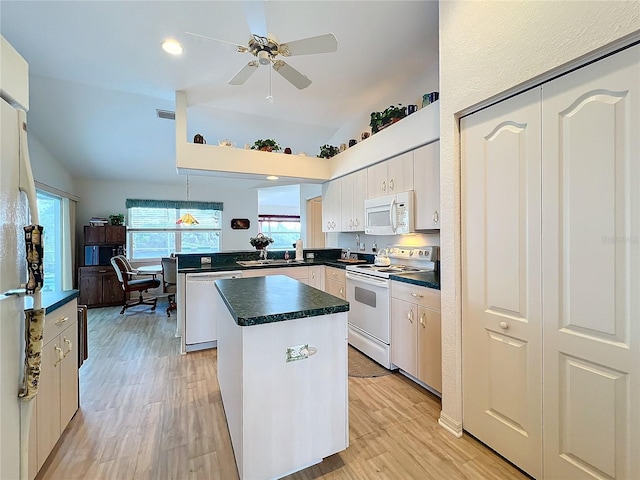 kitchen featuring dark countertops, light wood finished floors, a kitchen island, a peninsula, and white appliances