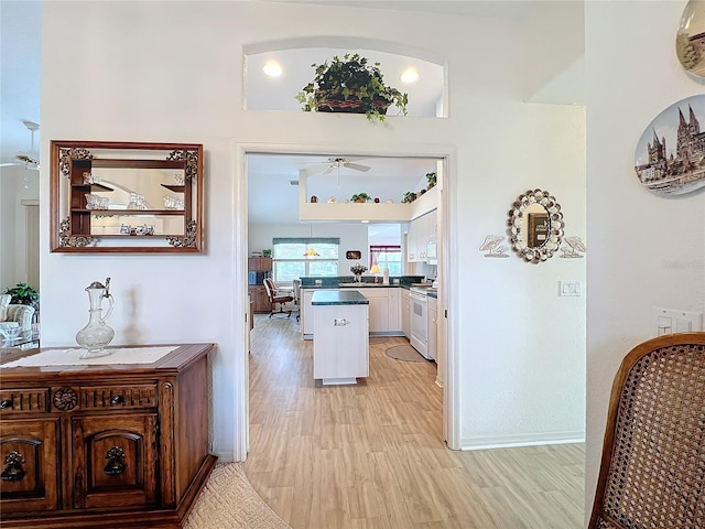 hallway with baseboards and light wood-style floors