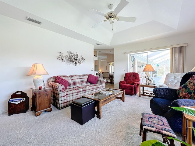 carpeted living room featuring ceiling fan and a tray ceiling