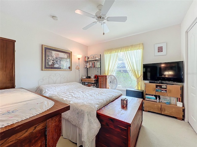 bedroom featuring light carpet and a ceiling fan