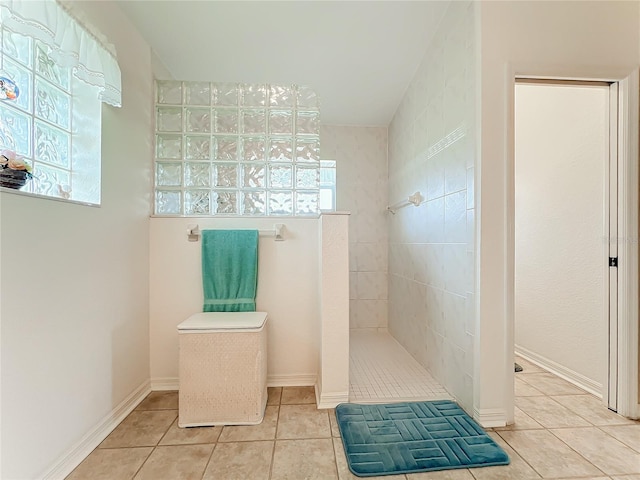 bathroom featuring tile patterned floors, baseboards, walk in shower, and a wealth of natural light