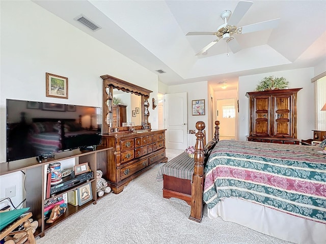 bedroom with ceiling fan, light carpet, and a tray ceiling