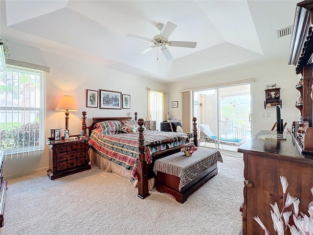 carpeted bedroom featuring access to outside, ceiling fan, and a raised ceiling