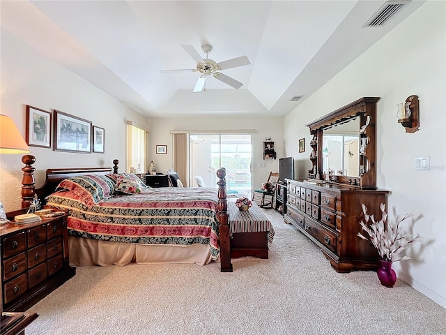 carpeted bedroom with visible vents, a ceiling fan, access to outside, a tray ceiling, and baseboards