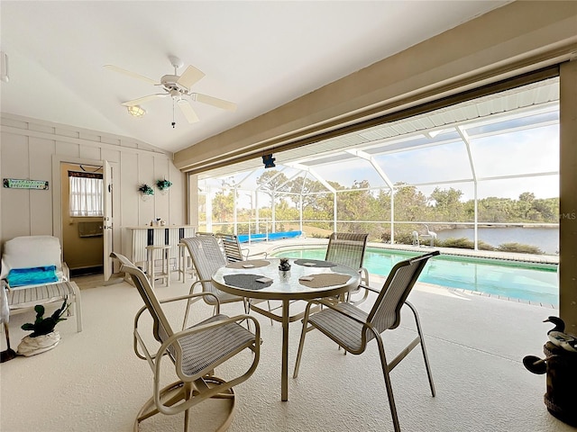 interior space featuring glass enclosure, ceiling fan, and a water view