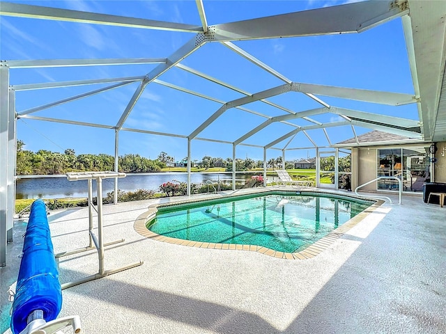 view of swimming pool with glass enclosure, a patio area, and a water view