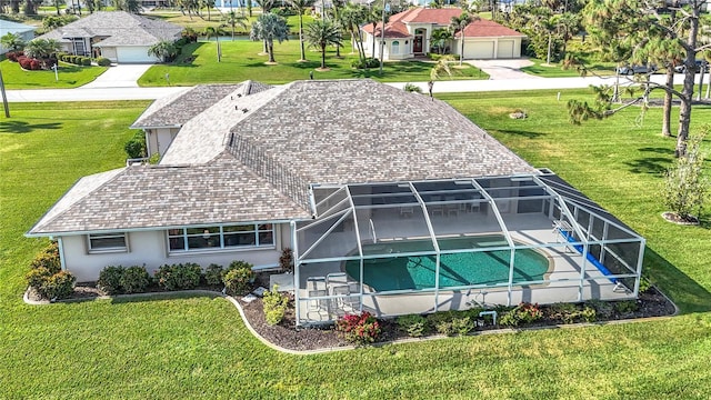 rear view of house with stucco siding, glass enclosure, a garage, an outdoor pool, and a patio