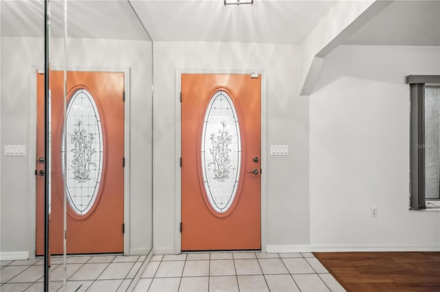 tiled entrance foyer with a healthy amount of sunlight