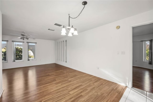 interior space featuring ceiling fan with notable chandelier and hardwood / wood-style floors