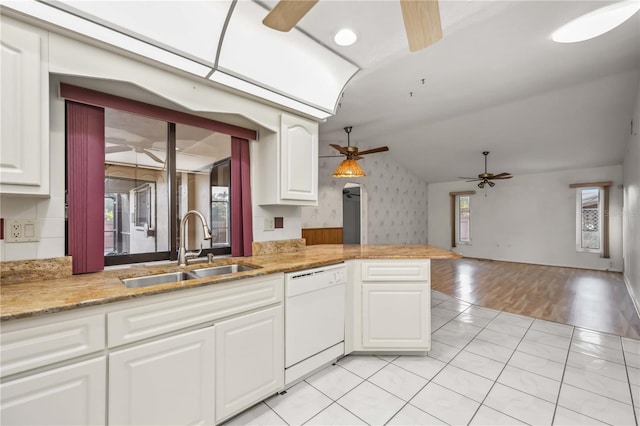 kitchen with vaulted ceiling, sink, white cabinets, white dishwasher, and kitchen peninsula