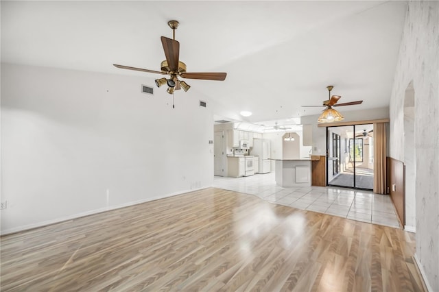 unfurnished living room featuring ceiling fan and light hardwood / wood-style floors