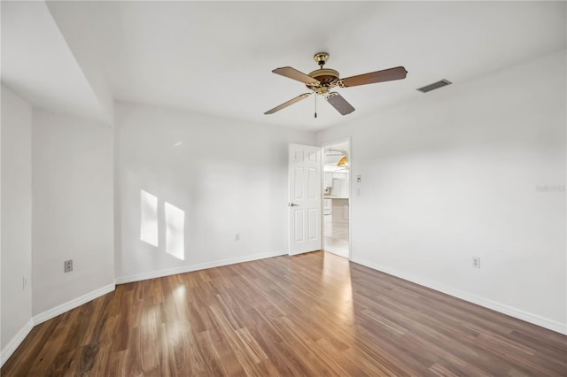 spare room with dark hardwood / wood-style flooring and ceiling fan