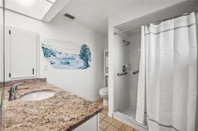 bathroom with tile patterned flooring, a skylight, vanity, curtained shower, and toilet