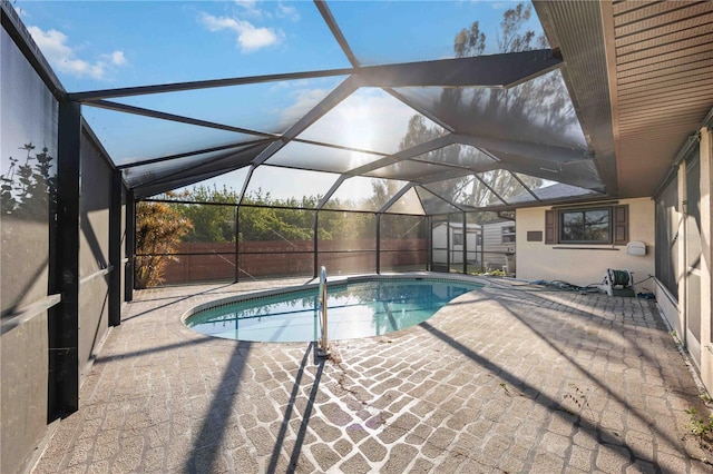 view of swimming pool with a patio area and glass enclosure