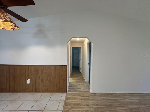 4204 Cockrell St, Port Charlotte, FL 33948 - spare room with wood walls, wainscoting, arched walkways, light wood-style flooring, and lofted ceiling
