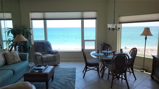 living room featuring a water view, tile patterned flooring, and a view of the beach