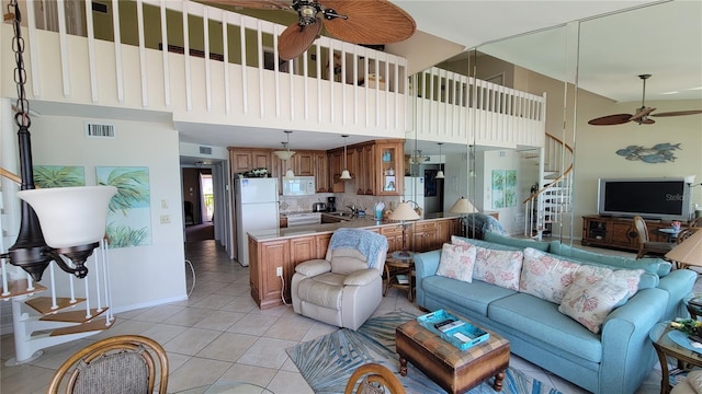 living room with ceiling fan, light tile patterned floors, sink, and a high ceiling