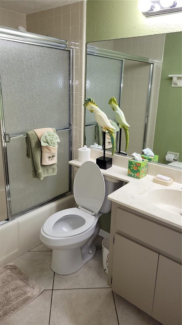 full bathroom featuring toilet, tile patterned flooring, enclosed tub / shower combo, and vanity