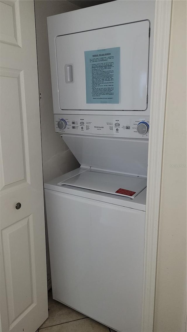 washroom with stacked washer / dryer and light tile patterned floors