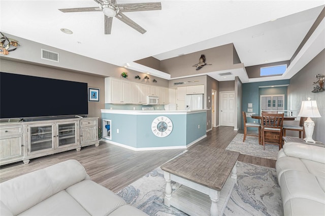 living room with ceiling fan and wood-type flooring