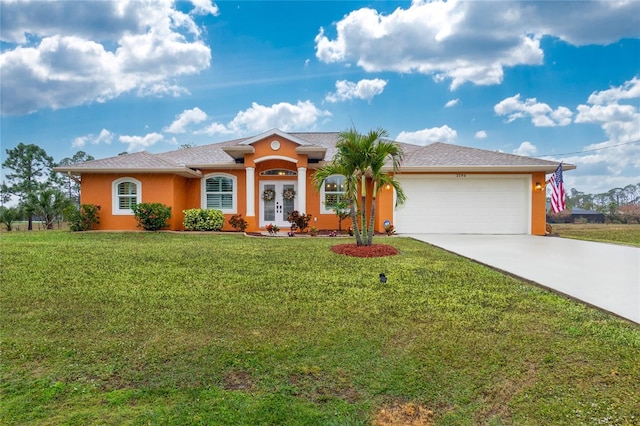 ranch-style home featuring a garage, a front yard, and french doors