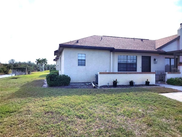 view of side of home with a yard