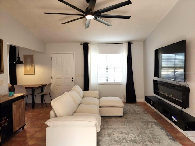 living room with ceiling fan, dark tile patterned floors, lofted ceiling, and a healthy amount of sunlight