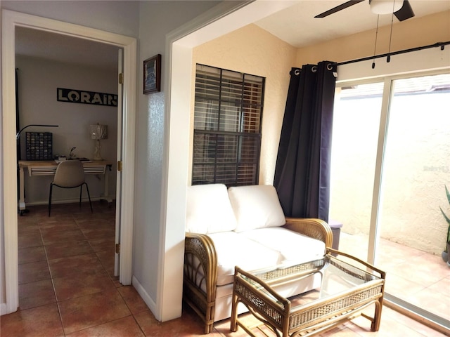 sitting room with ceiling fan and dark tile patterned floors