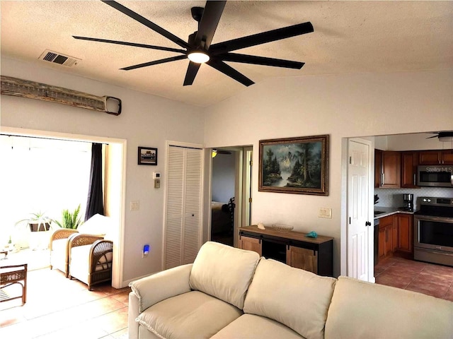 tiled living room featuring vaulted ceiling, ceiling fan, and a textured ceiling