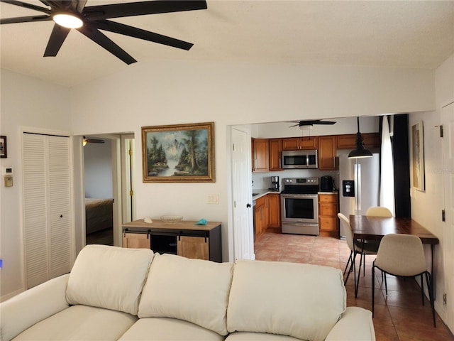 living room with vaulted ceiling, ceiling fan, and light tile patterned floors