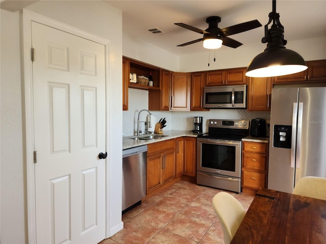 kitchen featuring light tile patterned floors, stainless steel appliances, tasteful backsplash, hanging light fixtures, and sink