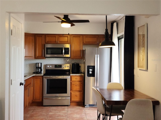 kitchen featuring ceiling fan, backsplash, pendant lighting, light tile patterned flooring, and stainless steel appliances