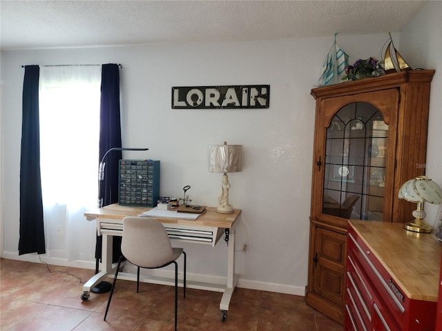 tiled home office with a textured ceiling