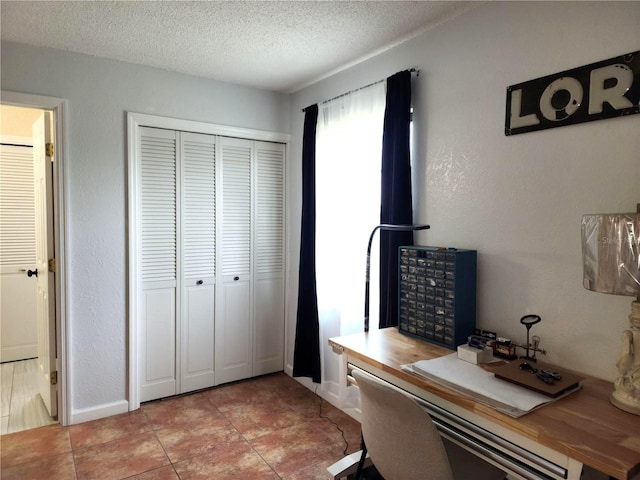 tiled home office featuring a textured ceiling