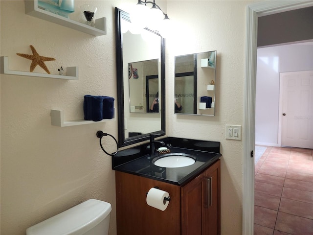 bathroom featuring toilet, tile patterned floors, and vanity