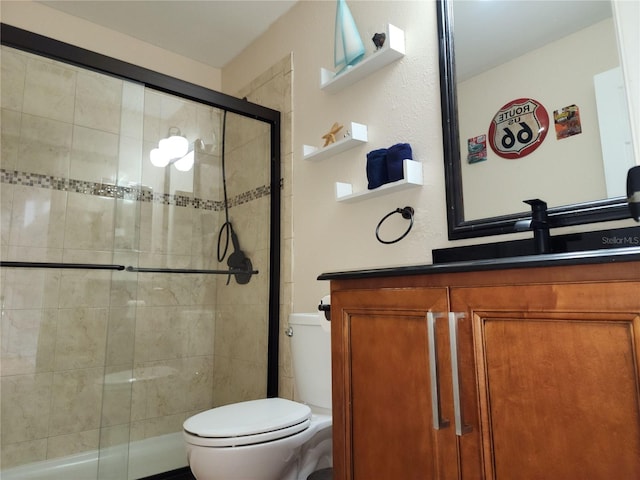 bathroom featuring toilet, vanity, and walk in shower