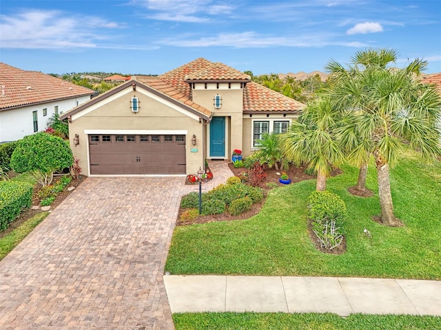 mediterranean / spanish-style home featuring a garage and a front lawn